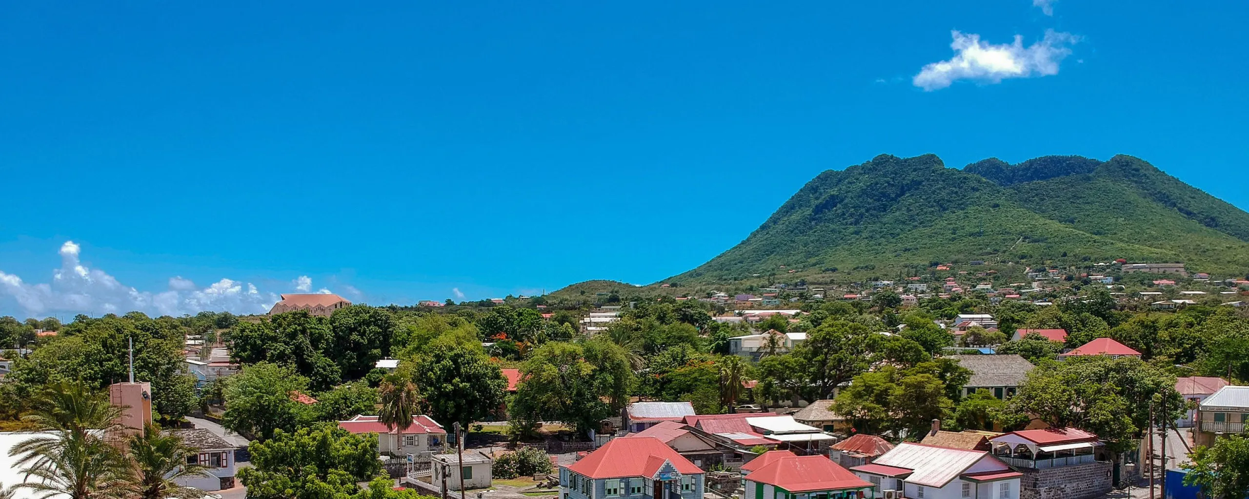 Aerial view of historic Oranjestad with The Quill rising behind it